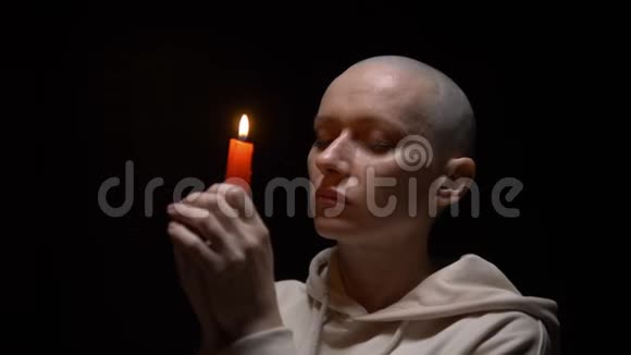 一个在黑色背景上戴蜡烛的秃头女人的肖像复制空间视频的预览图