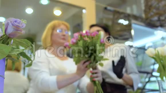 成年妇女在花店的监督下学会制作花束视频的预览图