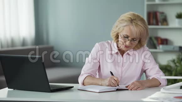 成熟的女人创造购物清单在记事本上写计划忙碌的家庭主妇视频的预览图