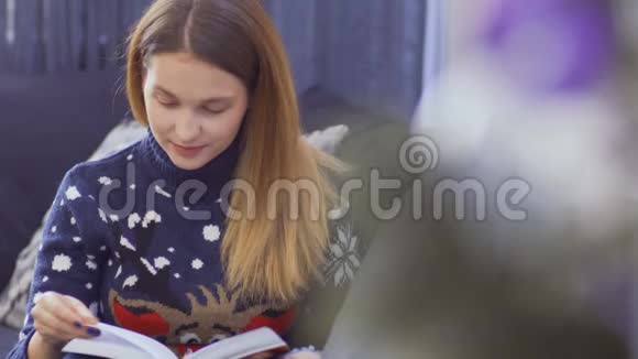 小女孩在圣诞树附近看书视频的预览图