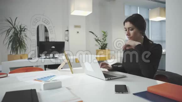 有魅力的女商人在办公室工作看着相框视频的预览图