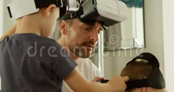父亲和孩子在家使用虚拟现实耳机视频的预览图