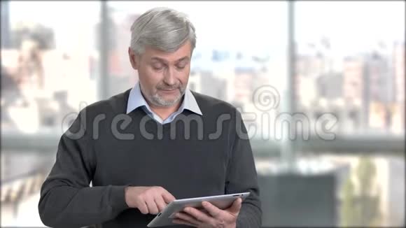 成熟的男人在数码平板电脑上打字视频的预览图