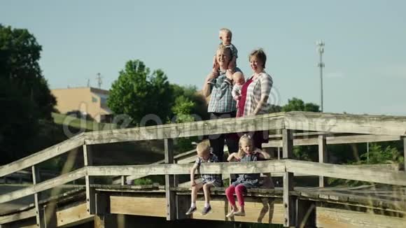 幸福的家庭四个孩子站在公园的桥上全高清视频的预览图