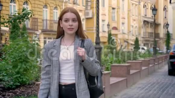 年轻自信的女人带着姜发在城市里散步展望未来黄色的建筑背景视频的预览图