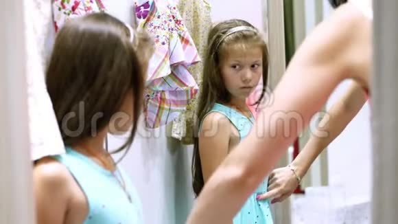 购物在大商店的试衣间漂亮严肃的女孩一个孩子试穿新衣服选择买什么这就是视频的预览图