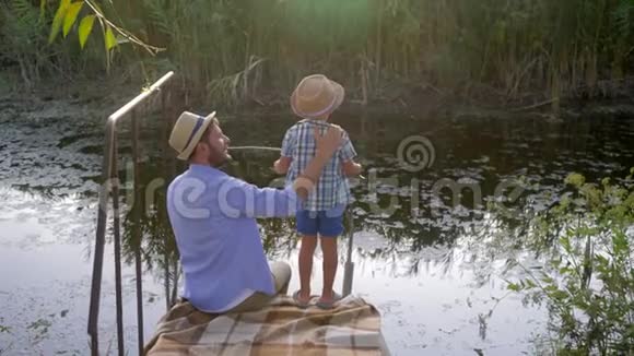 父子俩一起在小河边钓鱼度假期间家庭娱乐愉快视频的预览图
