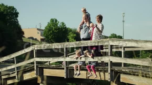 幸福的家庭四个孩子站在公园的桥上全高清视频的预览图