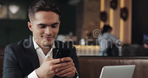 帅哥使用智能手机坐在咖啡馆或同事办公室企业家成功的肖像视频的预览图