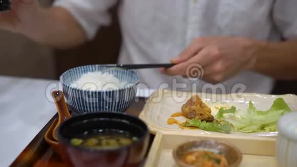 一个年轻人在日韩咖啡馆吃亚洲食物的慢镜头视频的预览图
