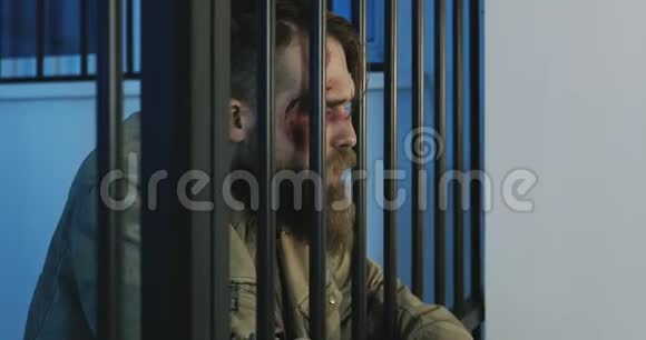 监狱牢房里一个留着胡子的流浪汉的特写视频的预览图