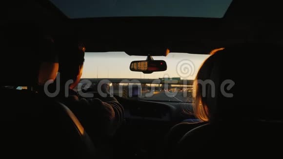 一对年轻夫妇坐在高速公路上有个玻璃舱口的车里视频的预览图