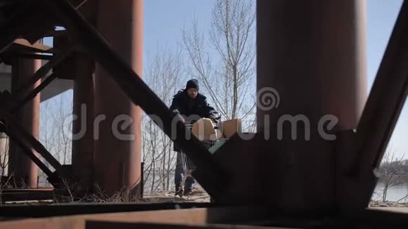 无家可归的人在桥下推着手推车视频的预览图