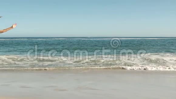 在海滩上做手推车的女人视频的预览图