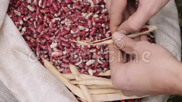 一个男人把豆子扔在袋子上视频的预览图