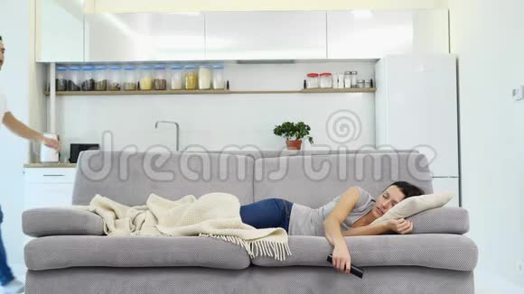 一个男人睡在地板上而他的妻子看电视视频的预览图