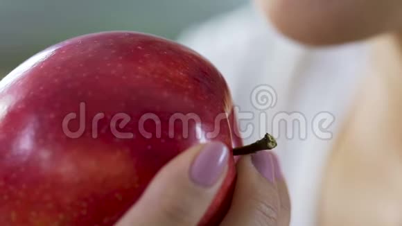 女人用健康的牙齿维生素和钙咬红多汁的苹果视频的预览图