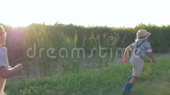 户外游戏小男孩和小女孩在农村玩接球和背光跑步视频的预览图