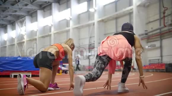 两个年轻的运动女子准备在跑道上跑步视频的预览图