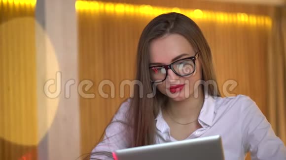 快乐的女孩在办公室里用她的新笔记本电脑在上面浏览互联网4K的女人在办公室里用她的新笔记本电脑视频的预览图