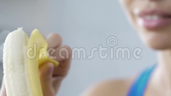 年轻女士吃香蕉微笑休息时吃快速健康的零食卡路里视频的预览图