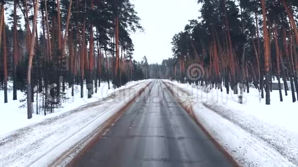 冬季雪林航拍令人叹为观止的自然景观冰冻的森林和黑暗的道路去森林视频的预览图