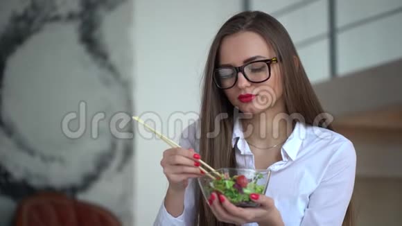 优雅的女商人在她的工作场所吃午饭的4K视频在办公室吃蔬菜沙拉的女人4千克视频的预览图