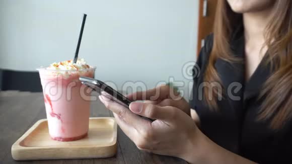 年轻女性使用智能手机在客房咖啡馆餐厅家庭或办公室喝一杯白咖啡视频的预览图