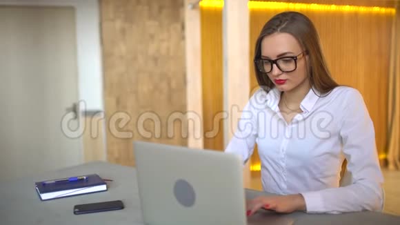 在办公室里用笔记本电脑工作的漂亮女商人的特写4千克视频的预览图