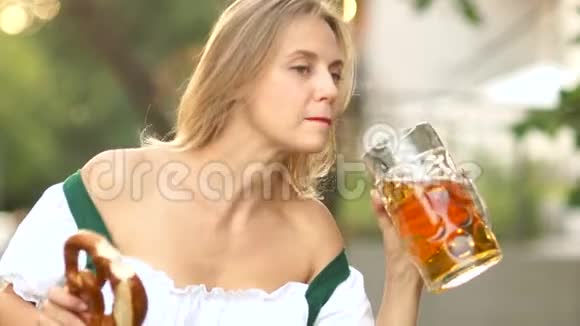啤酒节啤酒节成熟的女人穿着传统的巴伐利亚西装贪婪地大口喝啤酒好笑的笑视频的预览图