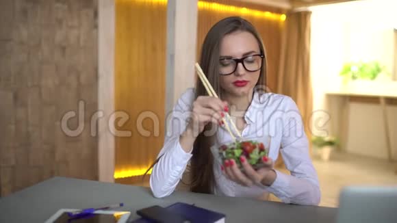 在办公室吃午餐蔬菜沙拉忙碌的女商人在办公室吃新鲜沙拉视频的预览图