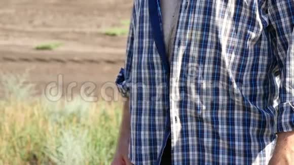 一个穿格子衬衫的男人的大毛肚一个男农民站在田里视频的预览图