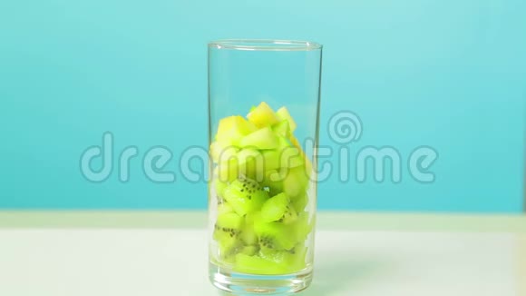 在一个玻璃玻璃片中切下一个猕猴桃和苹果的水果片玻璃旋转成圆视频的预览图