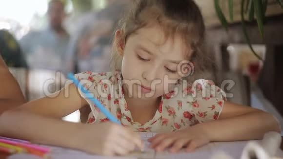 小女孩在咖啡馆里画画等待点菜餐馆里的小孩视频的预览图