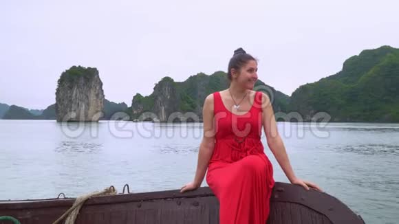 在船边走船边微笑的女人越南美丽的黑发女郎穿着红色的裙子漂浮在船上旅行视频的预览图