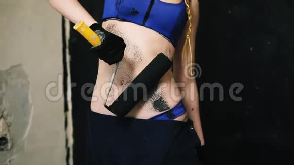 充满激情的女人用滚筒画她的肚子穿着一件内衣粉刷墙壁视频的预览图