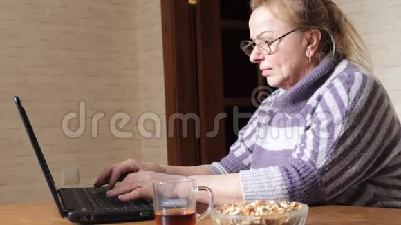 老年妇女使用她的笔记本电脑进行社交网络交流视频的预览图