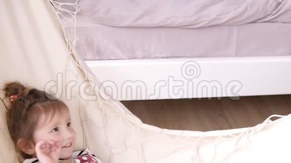 微笑的小女孩在白色的吊床上不寒而栗印度支视频的预览图