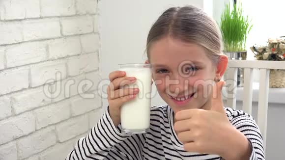 儿童在厨房早餐时喝牛奶女孩品尝奶制品视频的预览图