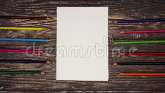 木制背景上的白纸和彩色铅笔停止运动视频的预览图