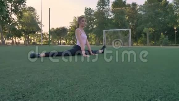 年轻自信的女人坐在公园的足球场上晨练健身模特锻炼视频的预览图