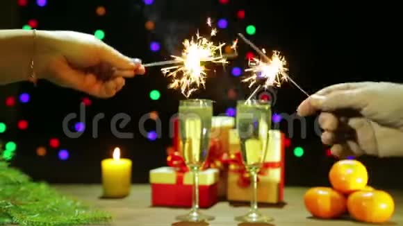 一个男人和一个女人在圣诞树附近点燃火花庆祝圣诞节新年视频的预览图