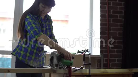 女木工在车间用圆形电锯锯木条视频的预览图