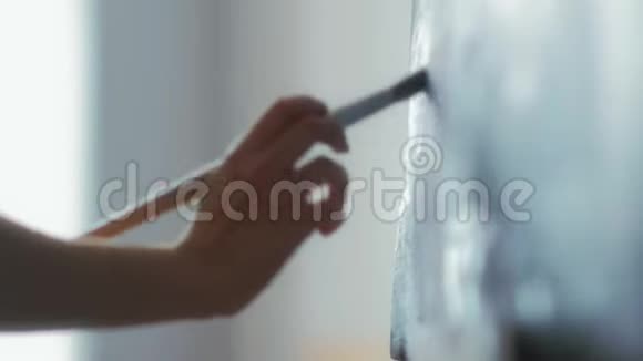 艺术家的特写他的手握着画笔在油画上作画视频的预览图