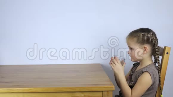 小女孩一边喝着杯子里的水视频的预览图
