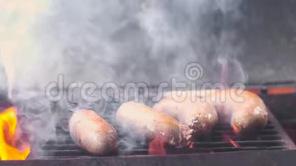 烤香肠烧烤架上的猪肉香肠很多烟和火特写镜头慢镜头视频的预览图