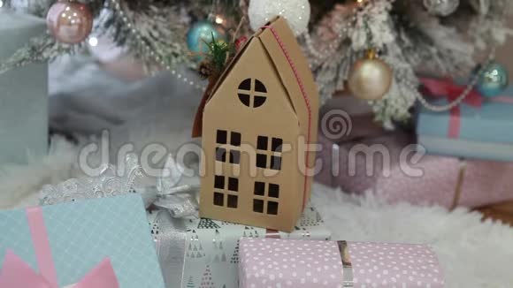 在圣诞礼物中纸板屋在圣诞树下的喜庆室内视频的预览图