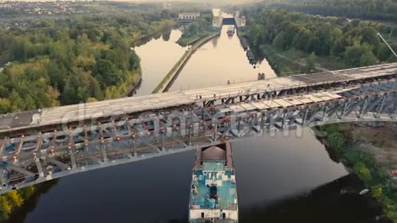 船闸区驳船在航运通道上的移动和桥梁施工的空气视图视频的预览图