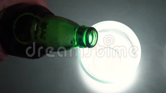 往杯子里倒啤酒动作镜头啤酒倒入玻璃上的纹理背景啤酒杯的俯视图视频的预览图