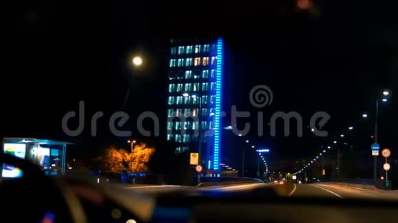 汽车在建筑物的背景下行驶晚上的晚上慢动作捕捉蓝光视频的预览图